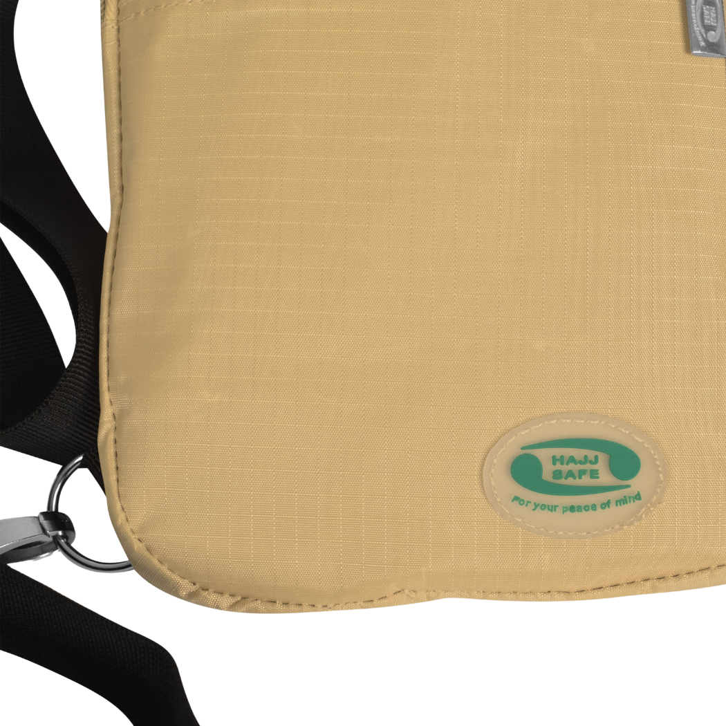 Close-up of the Hajj Safe logo badge on the beige Hajj bag for men