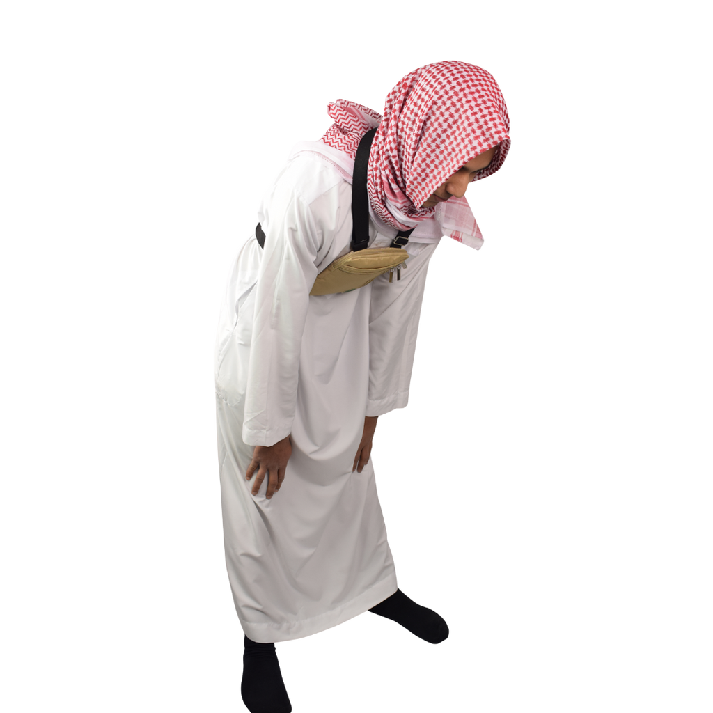 A man bowing in prayer wearing the beige Hajj bag for men on his chest